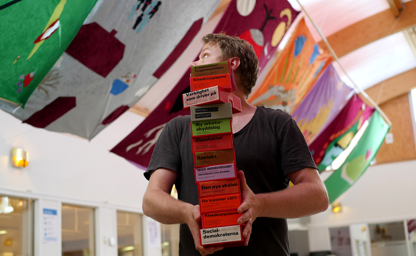 Konstnären Patrick Kretschek förbereder utställningen Rörelsens andning i ARABs bibliotek. Färgstarka ridåer hänger i taket.